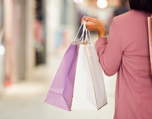 Person holding shopping bags in a Paris boutique.