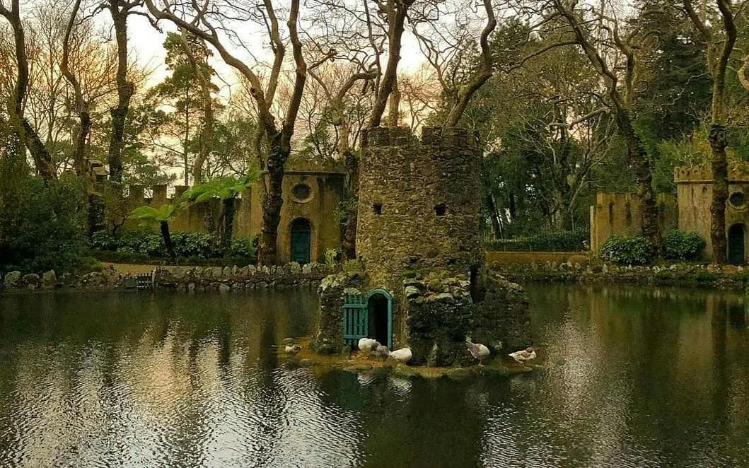 Stone tower on a pond surrounded by trees in Sintra, part of the Sintra Private Tour.