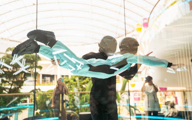 Young girl with instructor in iFly Dubai indoor skydive experience.