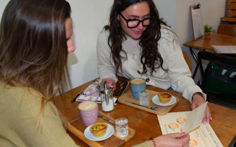 Two people enjoying coffee and pastries at a café during a food tour in Haarlem.