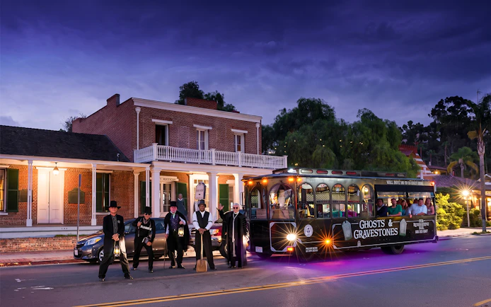 San Diego Ghosts & Gravestones tour trolley with guides in period costumes at night.