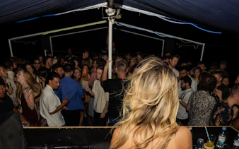 Crowd dancing on a night boat party in Split with live DJ and drinks.