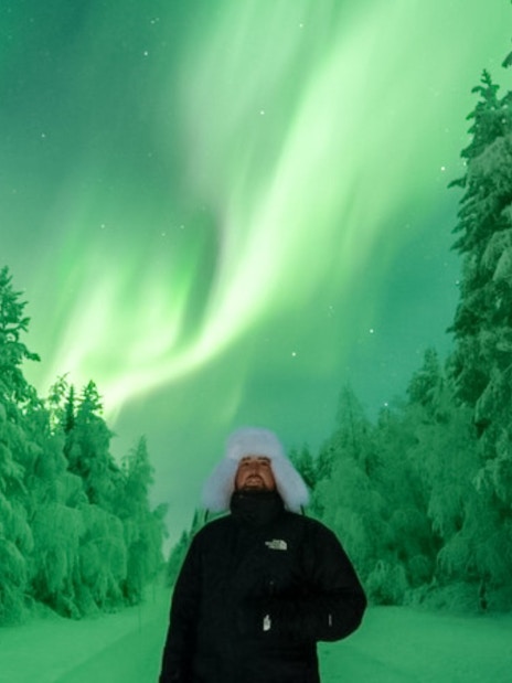 Guests viewing Northern Lights on snowy forest tour.