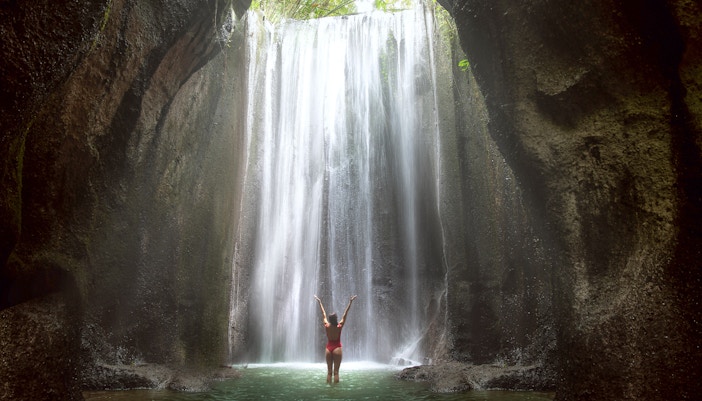 Woman looking at a majestic waterfall in Bali