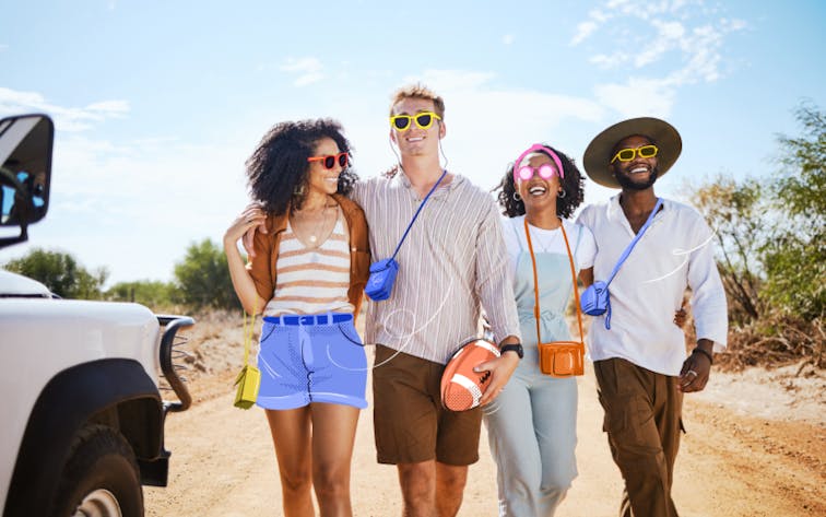 Friends walking together on a sunny day near a safari vehicle, enjoying a group adventure.