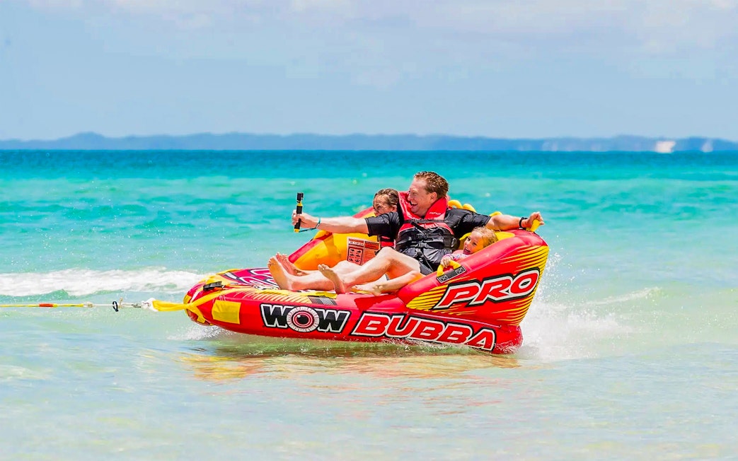 Tourists enjoying watersports on an inflatable raft at Fraser Island, K'gari.