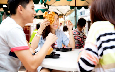 People enjoying Mickey Mouse-shaped waffles at Disneyland Hong Kong.