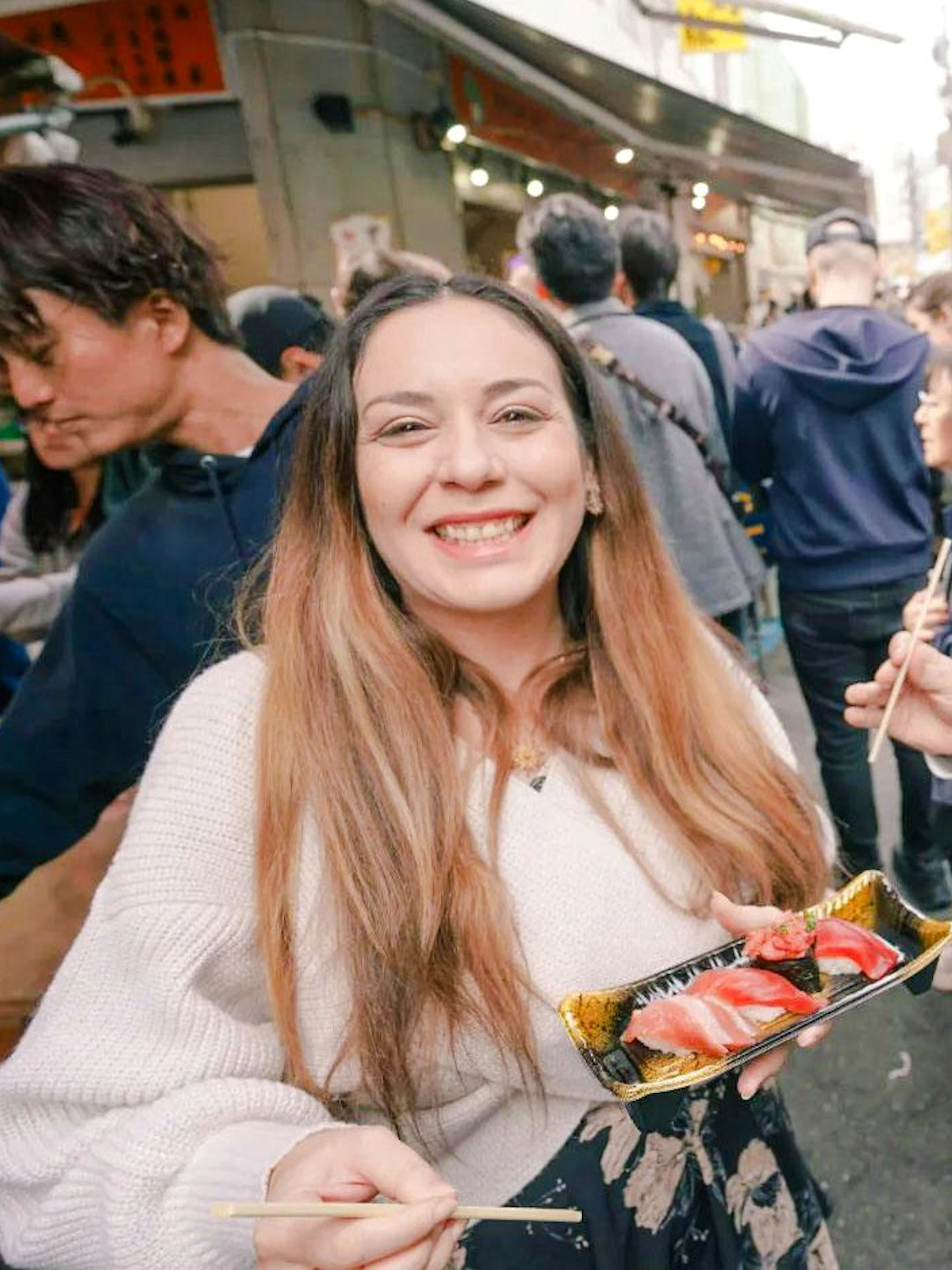 Tourists sampling sushi at Tsukiji Fish Market in Tokyo.
