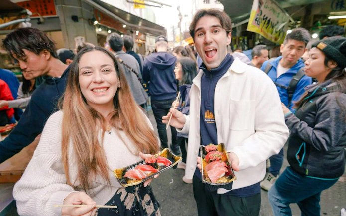 Tourists sampling sushi at Tsukiji Fish Market in Tokyo.