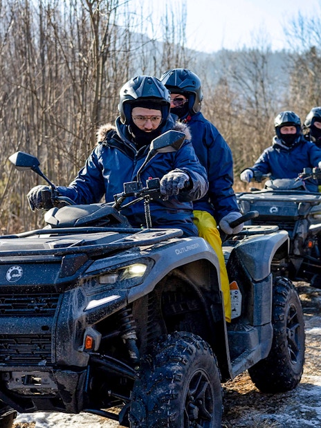 Quad biking group on snowy trail in Zakopane with guide, Poland.