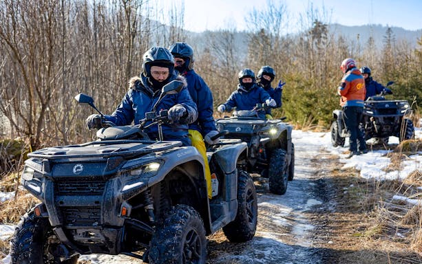 Quad biking group on snowy trail in Zakopane with guide, Poland.