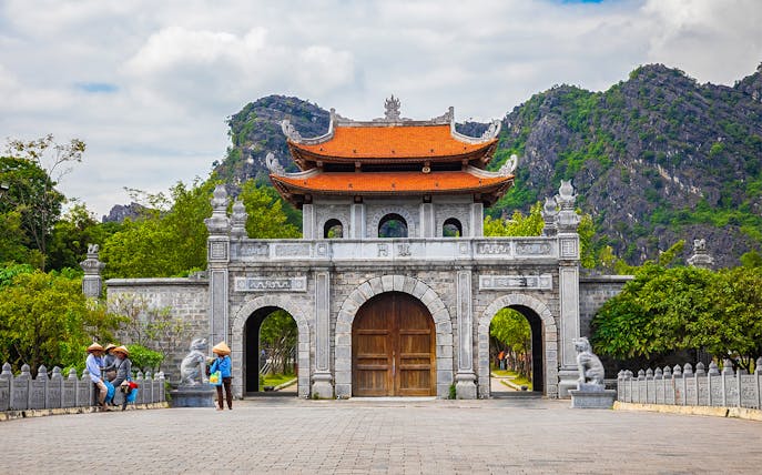 Hoa Lu ancient gate with mountains in the background, part of the Tam Coc, Hoa Lu & Mua Caves tour from Hanoi.