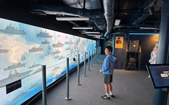 Visitor exploring naval ship exhibit on a self-guided tour.