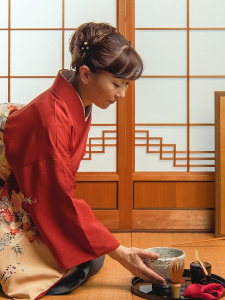 Woman in kimono preparing matcha tea during Mt Fuji day trip experience.