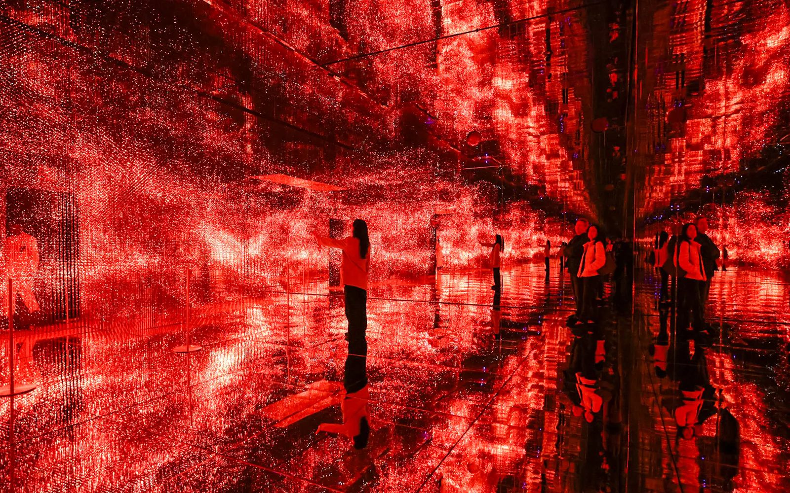 Visitors exploring immersive red light installation at Mercer Labs Museum of Art.