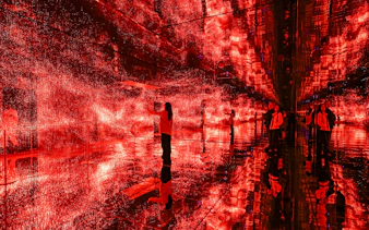 Visitors exploring immersive red light installation at Mercer Labs Museum of Art.
