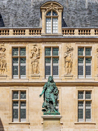 Statue of Louis XIV in front of the Carnavalet Museum, Paris facade.
