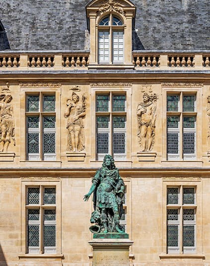 Carnavalet Museum courtyard with historic Parisian architecture and lush garden.