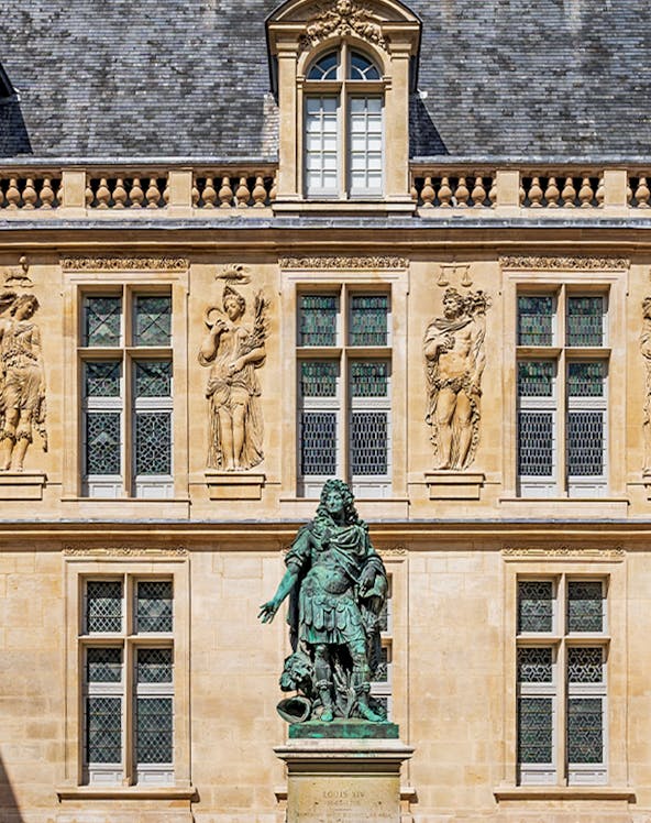 Statue of Louis XIV in front of the Carnavalet Museum, Paris facade.