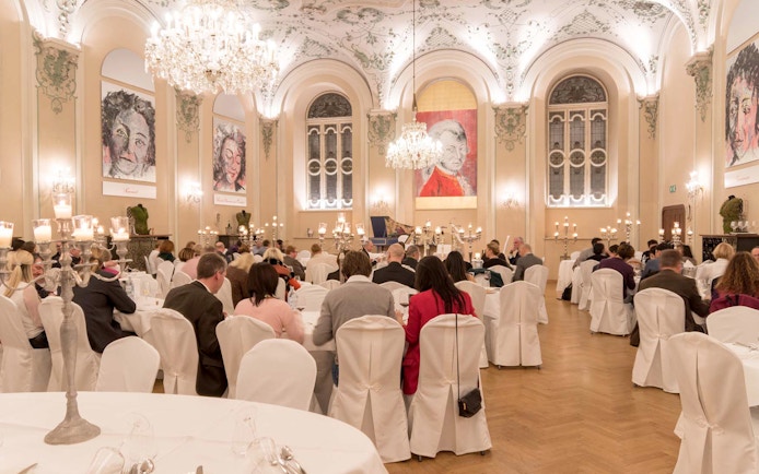 Musicians in period costumes performing at a Mozart concert in a historic Salzburg venue.
