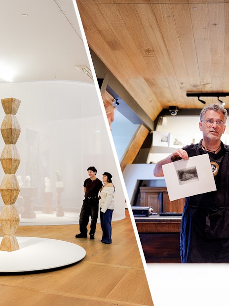 Visitors exploring art and a guide demonstrating a print at Rembrandt House Museum.