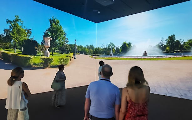 Visitors viewing a digital exhibit of a garden at Galeria de las Colecciones Reales.