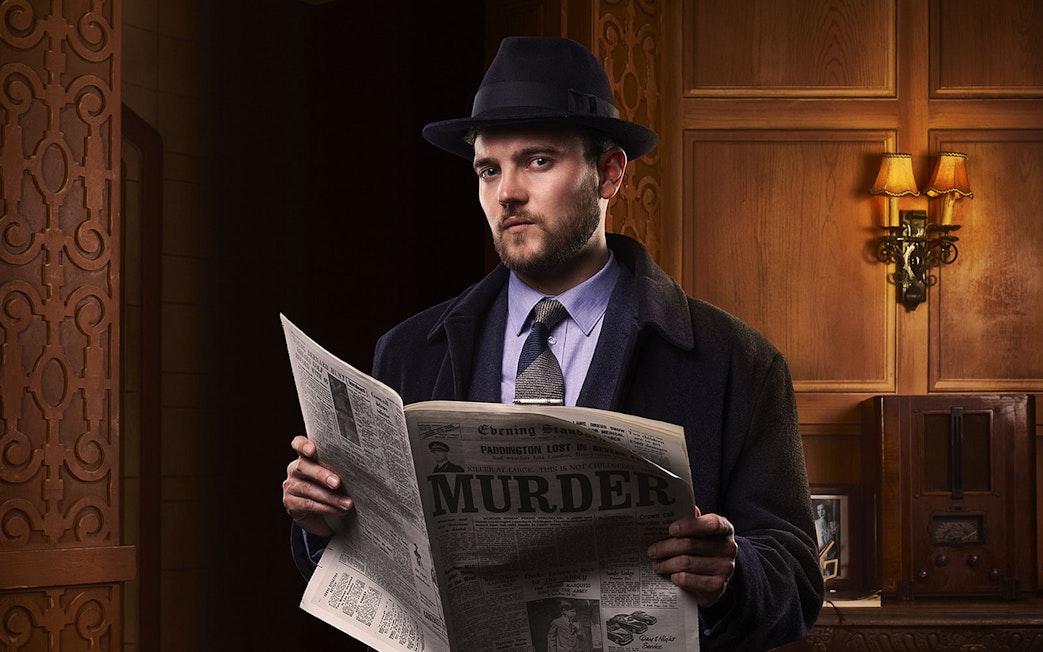 Man in vintage attire reading a newspaper with "Murder" headline, related to The Mousetrap play.