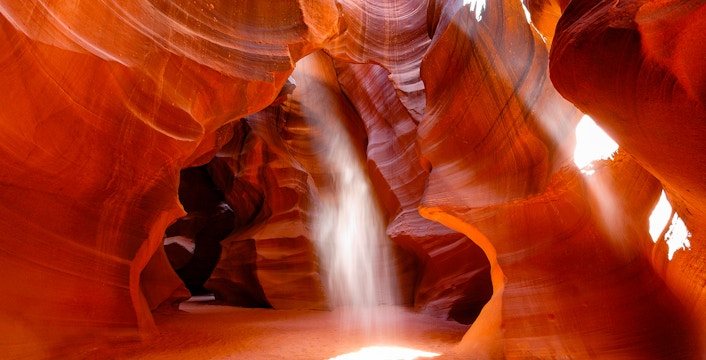 Antelope Canyon's swirling red sandstone formations with sunlight beams, Arizona.