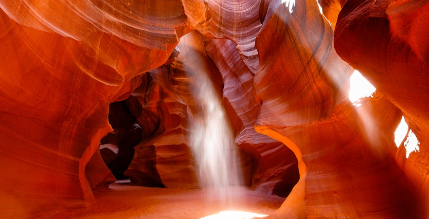 Antelope Canyon's swirling red sandstone formations with sunlight beams, Arizona.