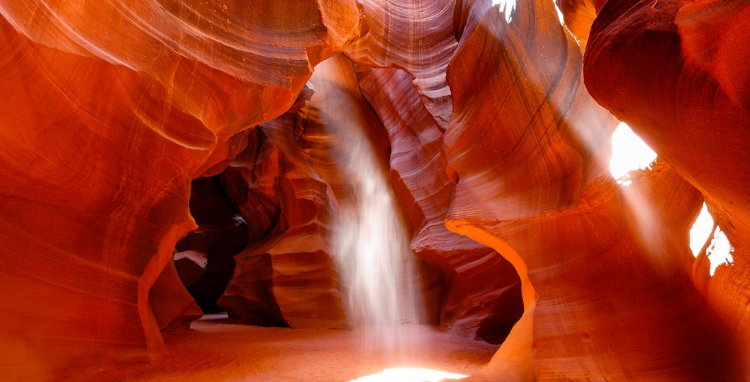 Antelope Canyon's swirling red sandstone formations with sunlight beams, Arizona.