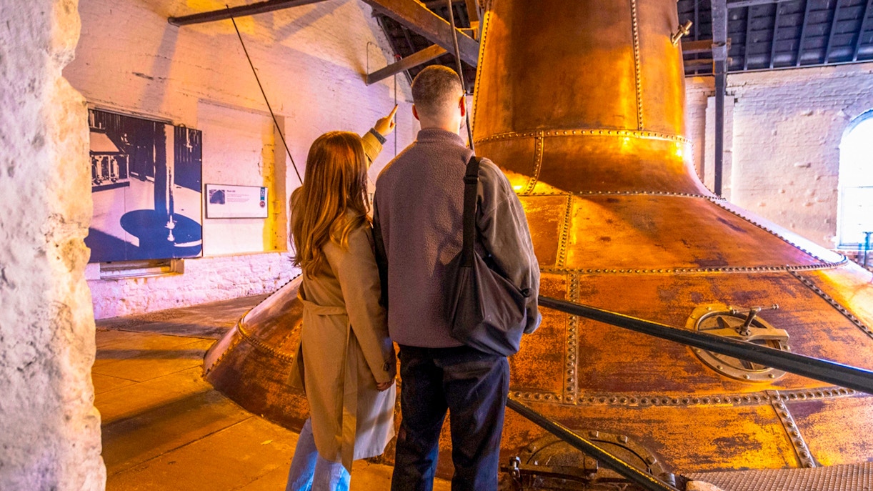Visitors exploring copper stills at Midleton Distillery during a behind-the-scenes tour.