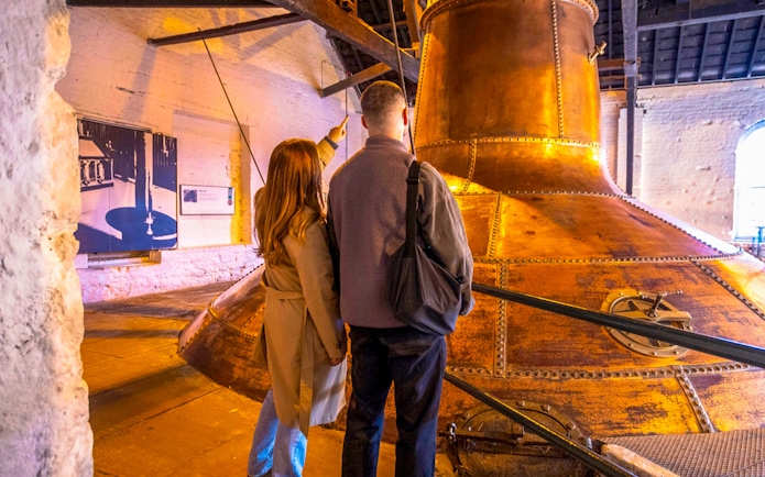 Visitors exploring copper stills at Midleton Distillery during a behind-the-scenes tour.