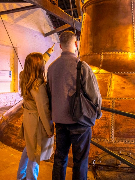 Visitors exploring copper stills at Midleton Distillery during a behind-the-scenes tour.