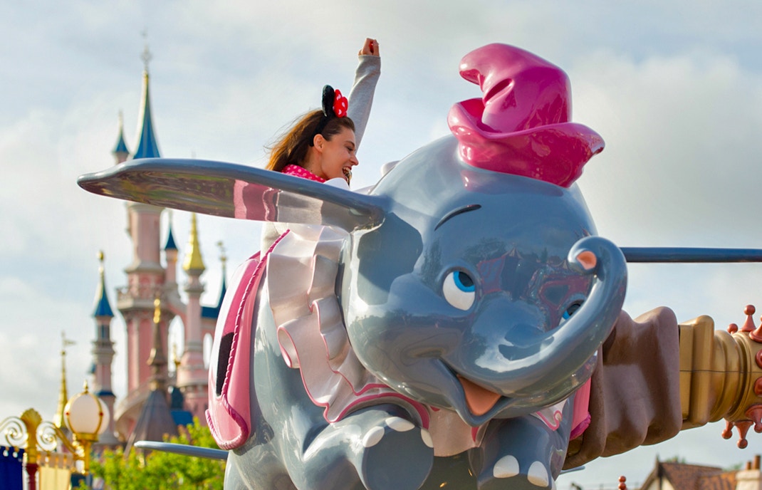 Dumbo the Flying Elephant ride with castle backdrop at Disneyland Paris.