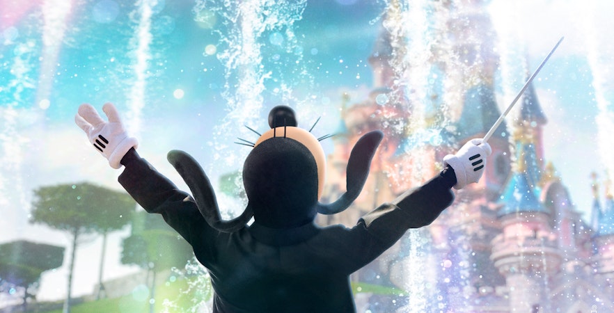 Goofy conducting an imaginary orchestra in front of Sleeping Beauty Castle at Disneyland Paris.