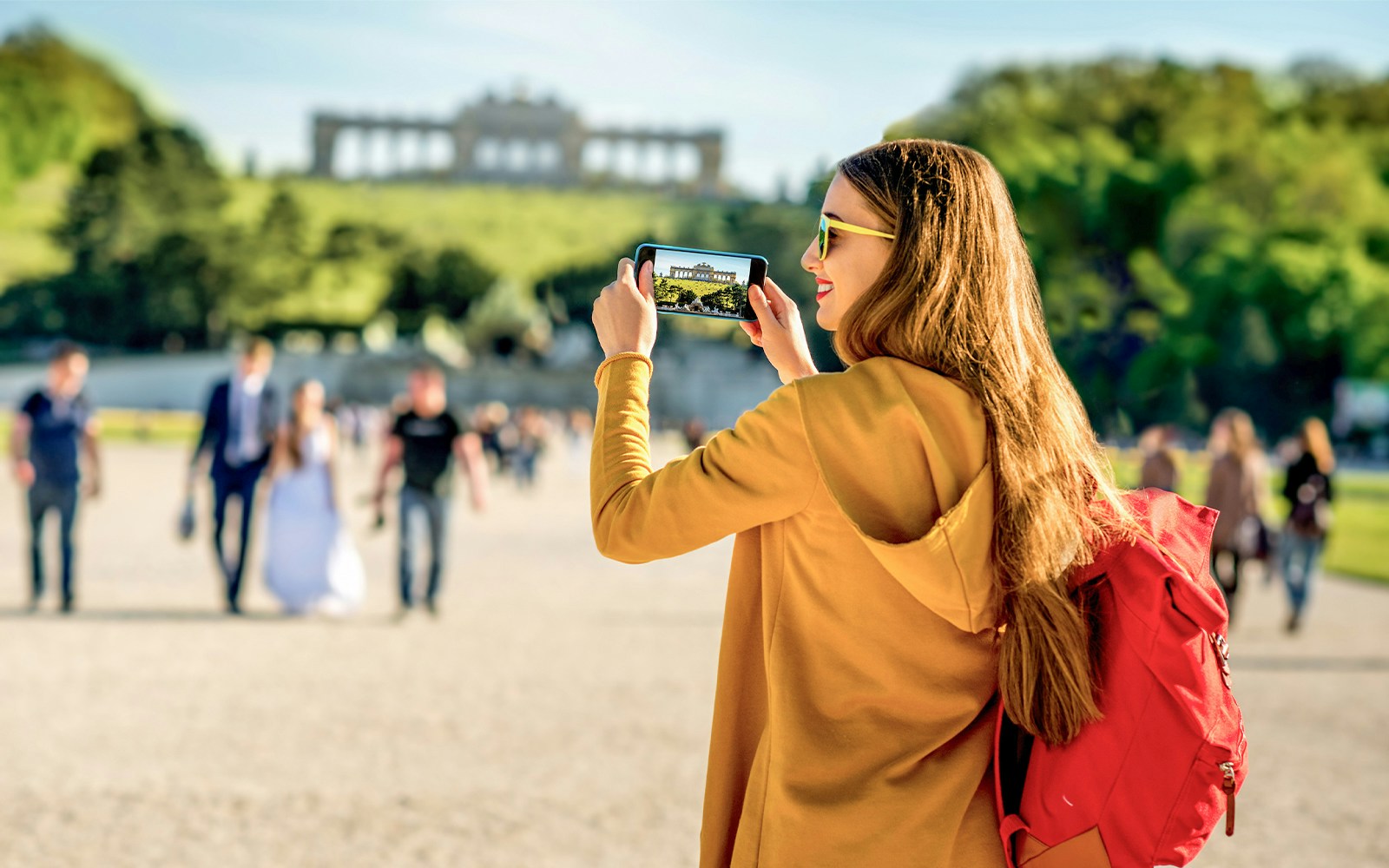 Visitor photographing Schönbrunn Palace gardens in Vienna.