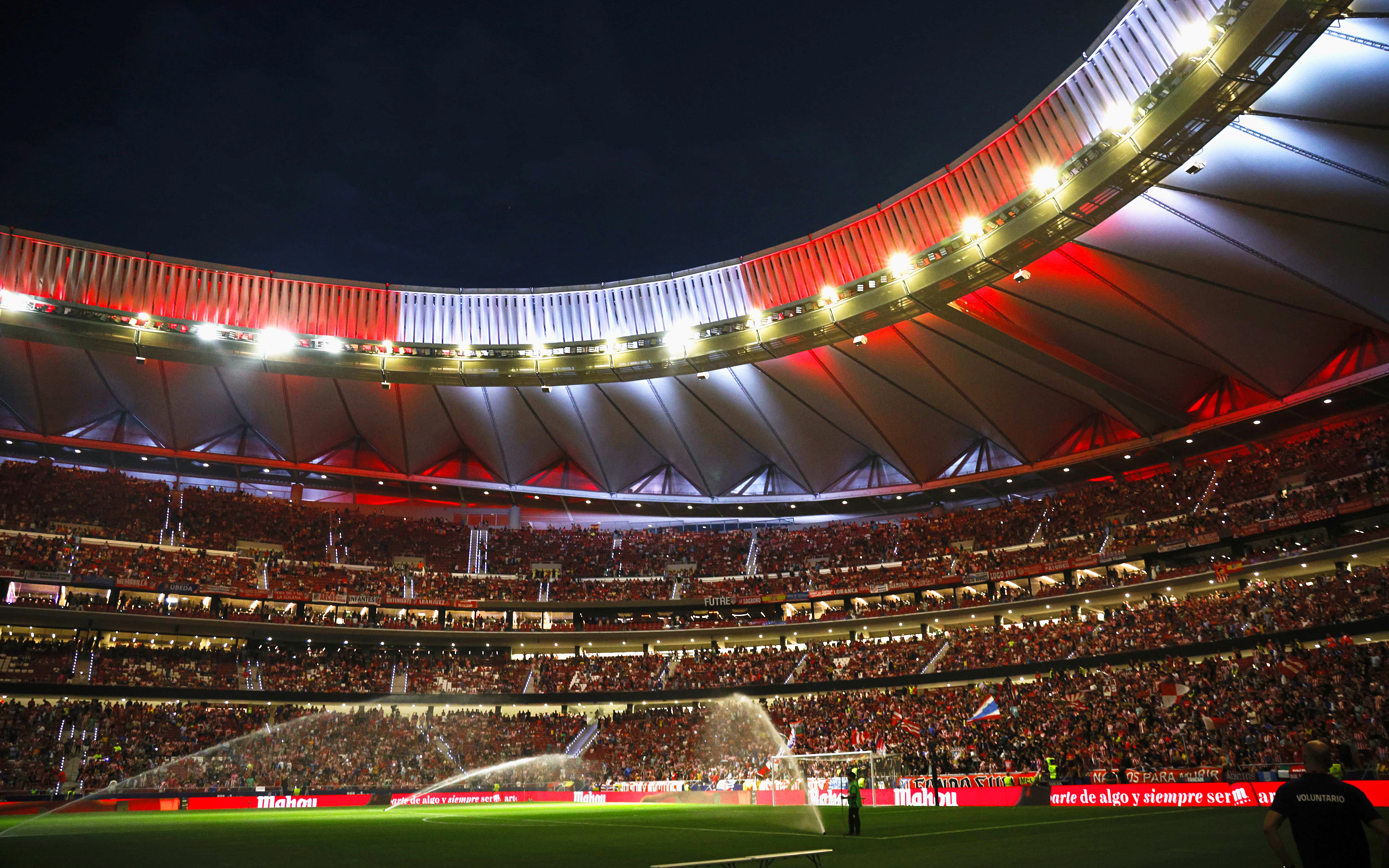 Wanda Metropolitano Stadium in Madrid, Spain, illuminated at night during a football match.