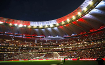 Wanda Metropolitano Stadium in Madrid, Spain, illuminated at night during a football match.