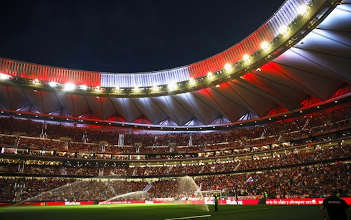 Wanda Metropolitano Stadium in Madrid, Spain, illuminated at night during a football match.