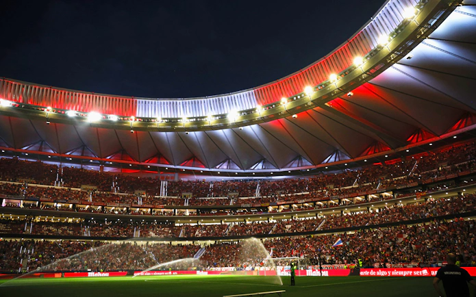Wanda Metropolitano Stadium in Madrid, Spain, illuminated at night during a football match.