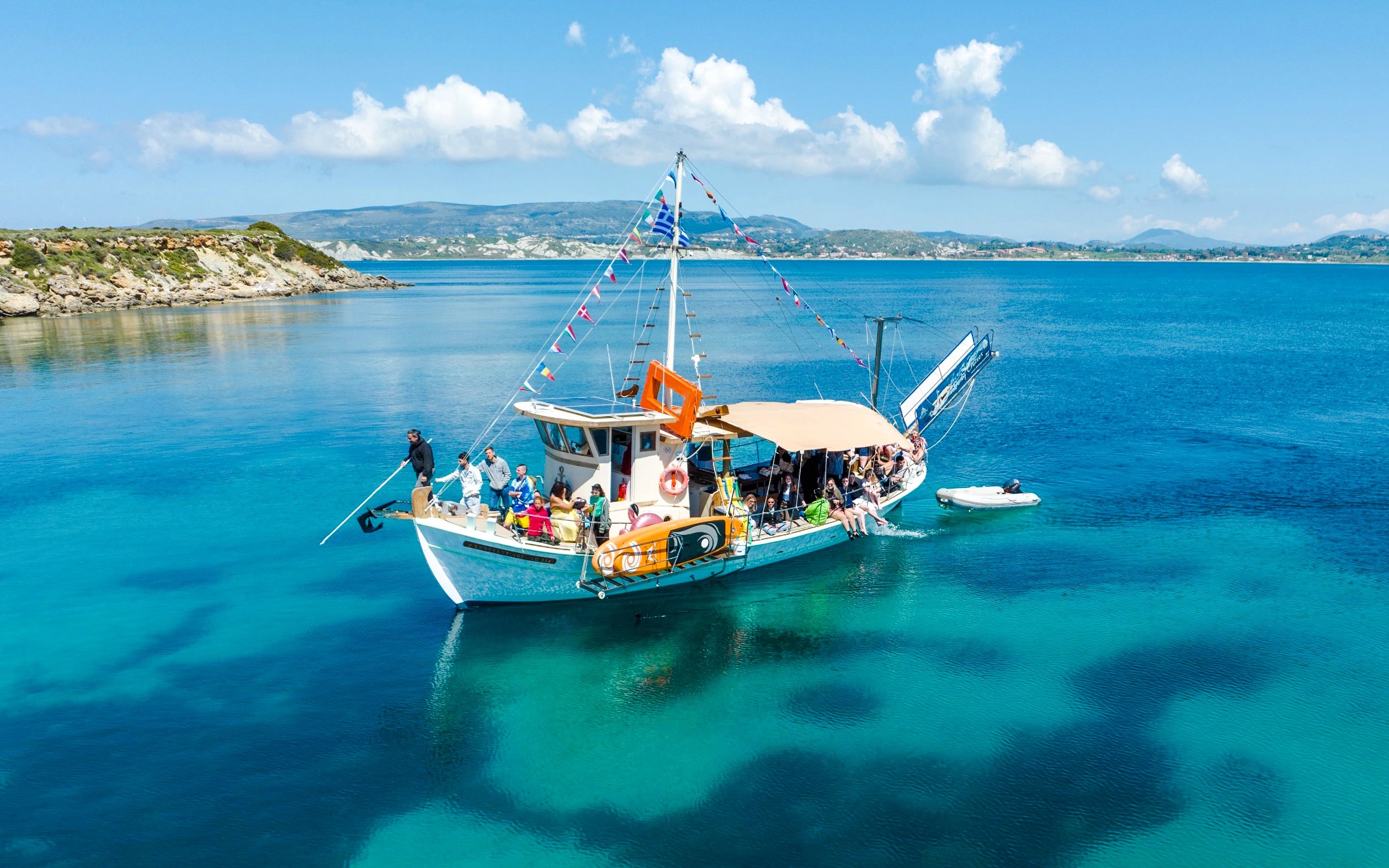 Cruise boat with passengers on clear blue waters near Kefalonia coast.