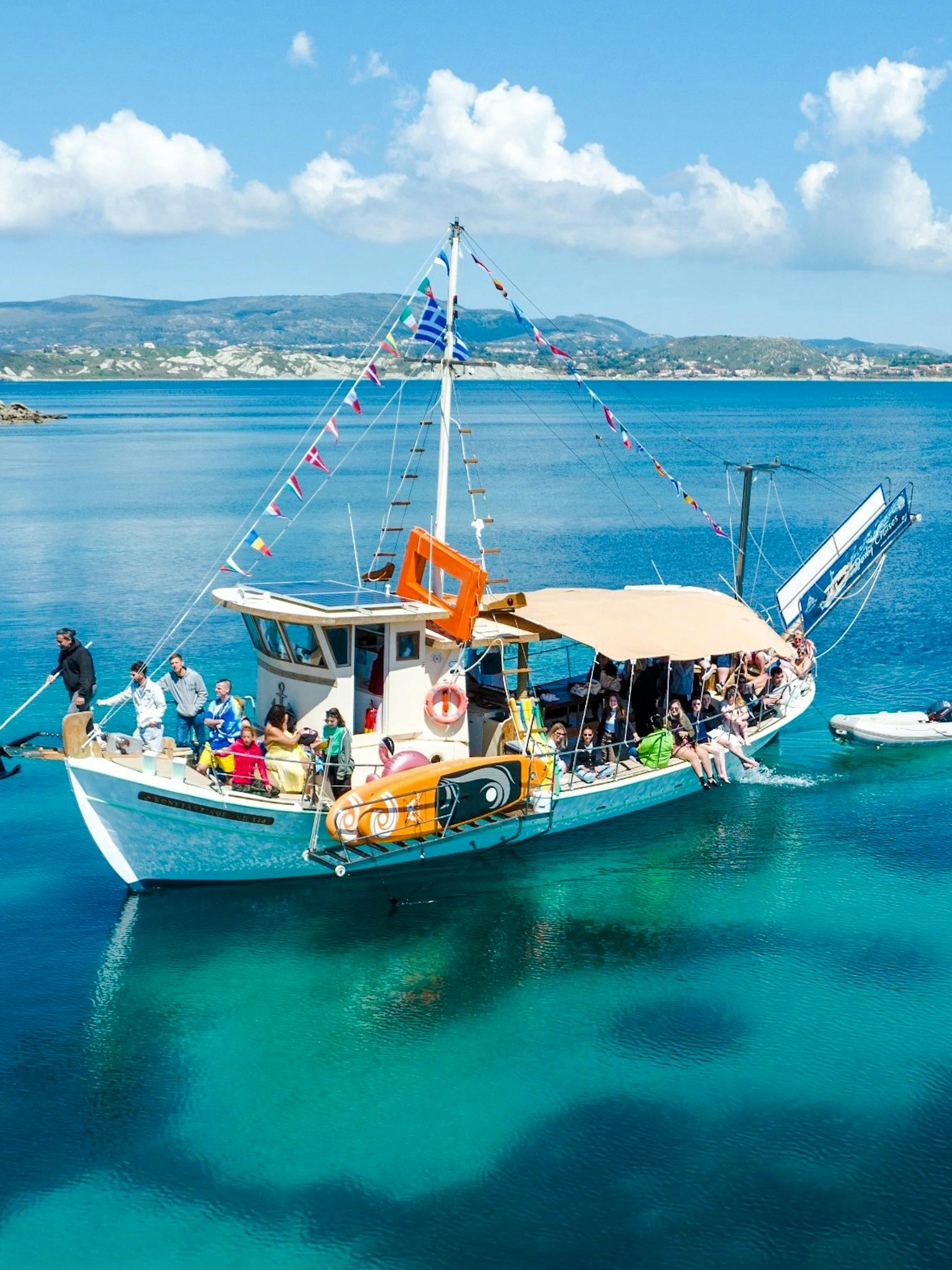 Cruise boat with passengers on clear blue waters near Kefalonia coast.