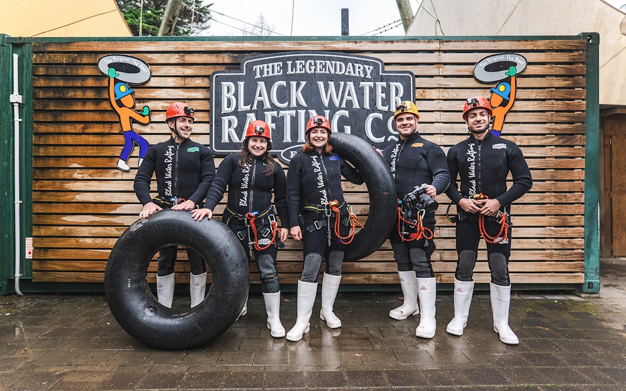 Group of people in wetsuits with inner tubes at Black Water Rafting, Waitomo.
