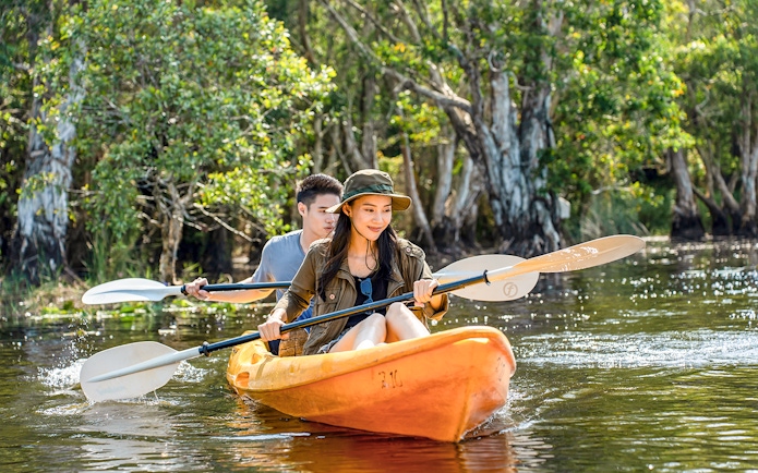 Couple kayaking through Langkawi Mangrove forest.