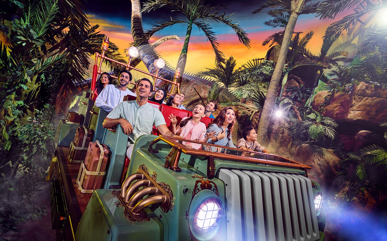 Group enjoying a theme park ride surrounded by tropical scenery in Dubai.