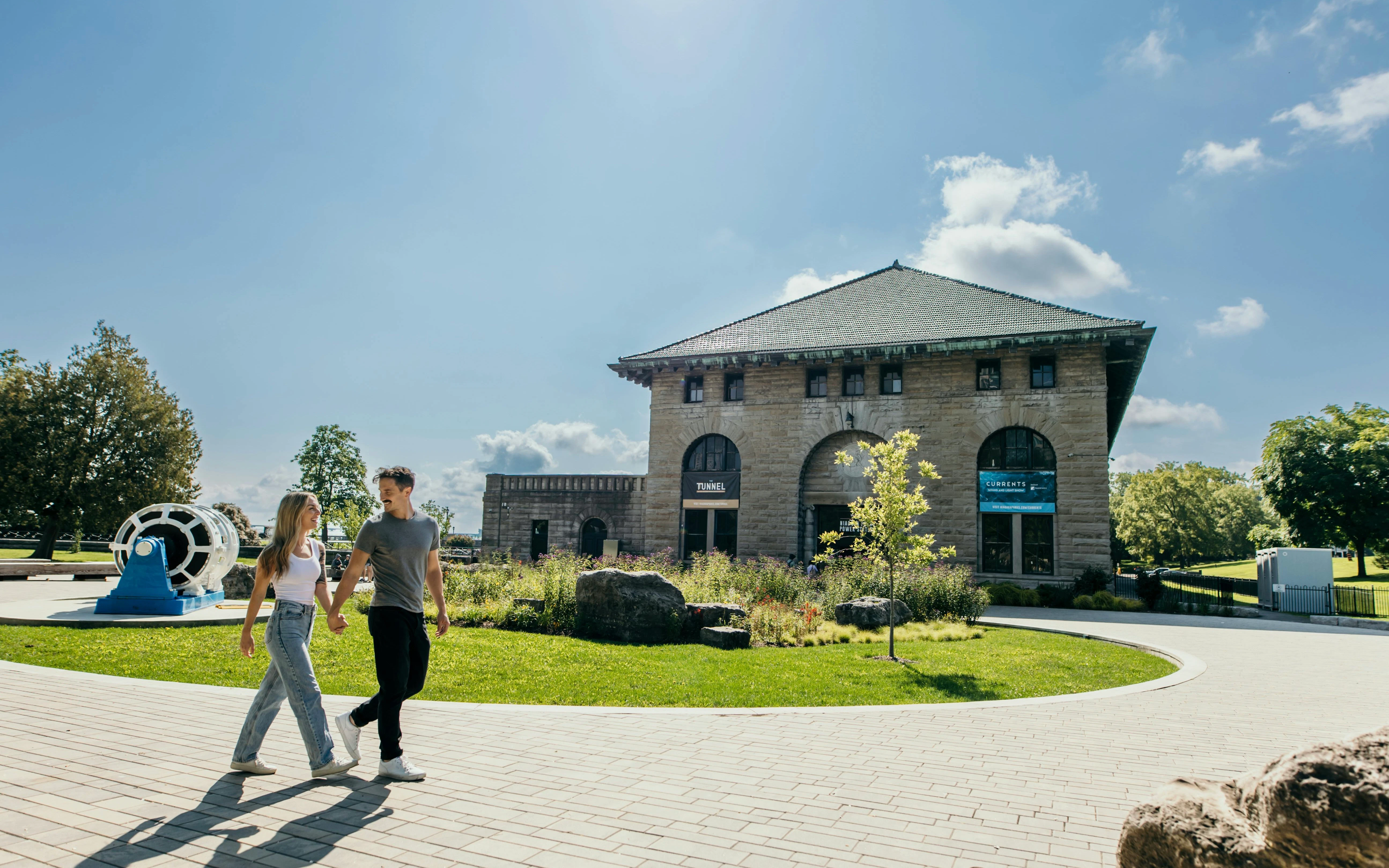 Couple walking outside Niagara Parks Power Station during daytime.