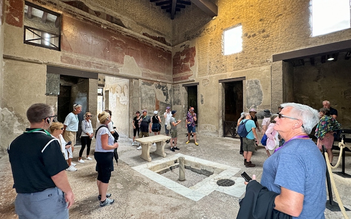 Visitors exploring ancient ruins at Herculaneum, Italy.