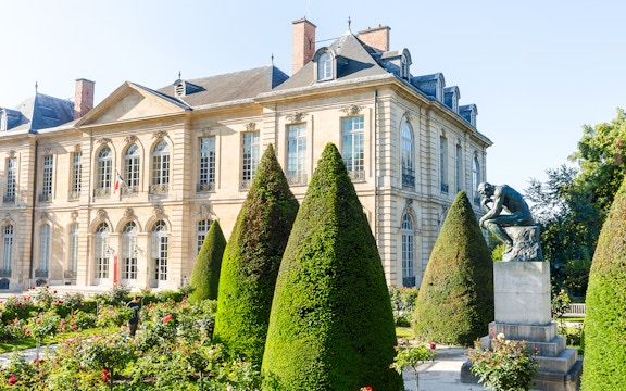 Rodin Museum garden with The Thinker sculpture and historic building in Paris.