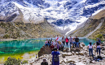 Group of hikers at Humantay Lake with snowy mountains, Cusco day hike.