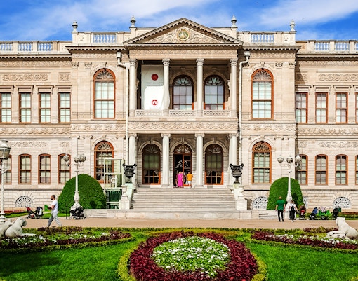 Dolmabahce Palace facade with ornate architecture and garden in Istanbul.